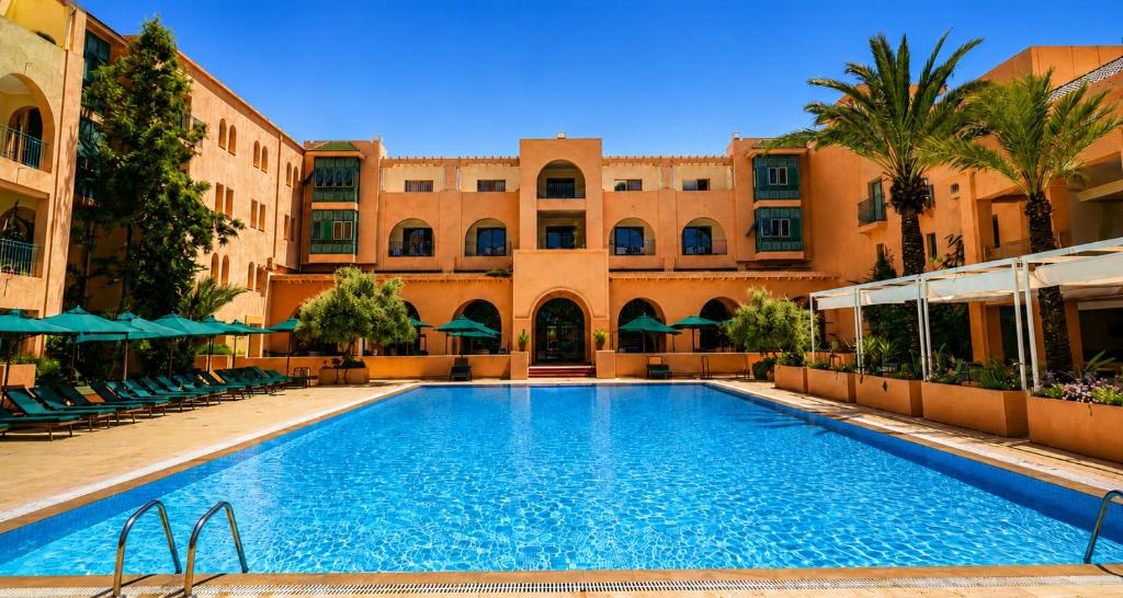 a large swimming pool in front of a building at Alhambra Thalasso in Hammamet