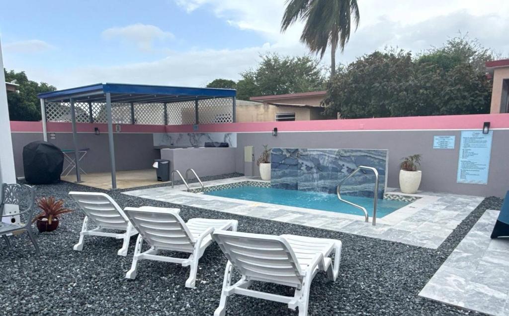 a group of chairs sitting around a swimming pool at Armonia Rosada in Cabo Rojo