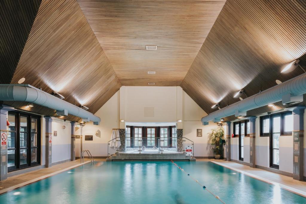 an indoor swimming pool with a wooden ceiling at Lancaster House Hotel in Lancaster