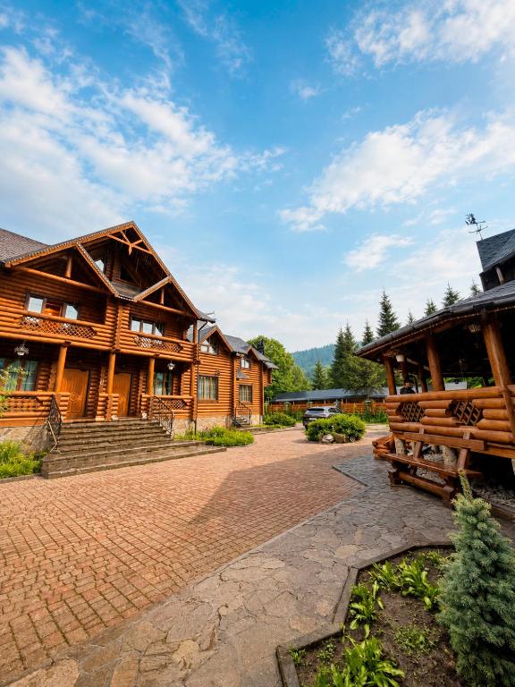 a large wooden house with a brick driveway at Дикий Кіт in Vorokhta