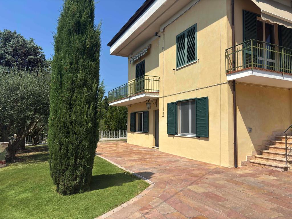 a large house with a tree in the yard at Villa Mario in Senigallia