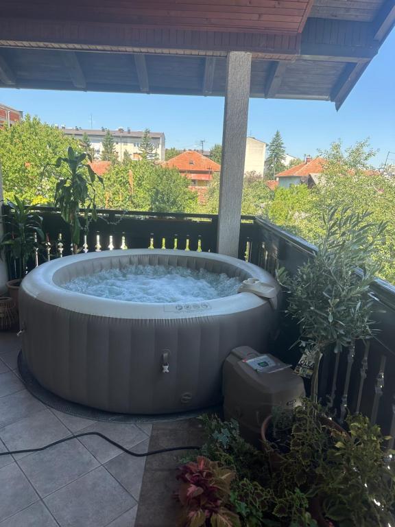 a hot tub on a patio with plants at Grand apartman in Banja Luka