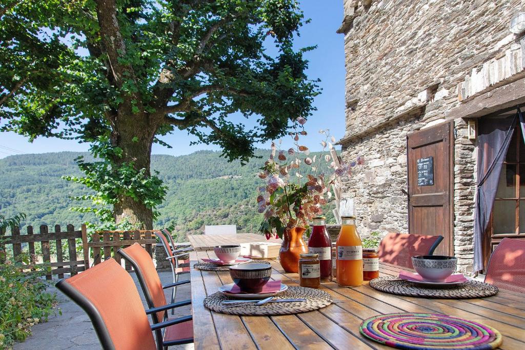 a wooden table with food on it on a patio at Chambres Et Table D'hôtes De Vernet in Saint-Germain-de-Calberte