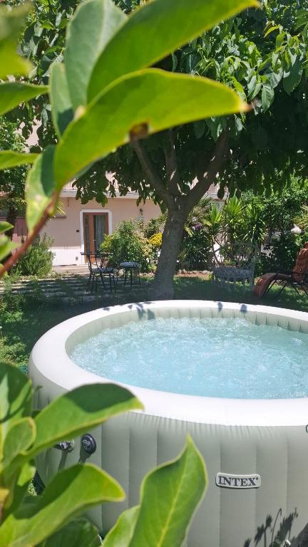 a hot tub in a yard with a tree at HedèraRooms in Agerola