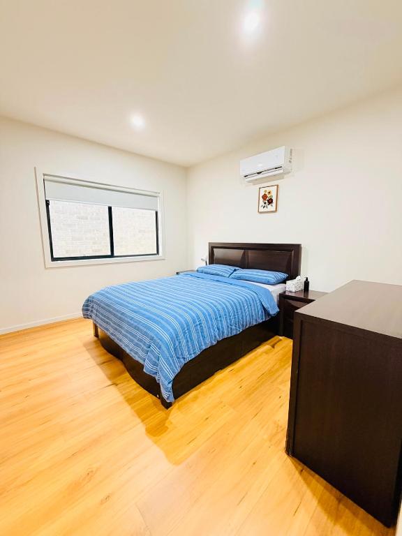 a bedroom with a large bed and a window at Comfort Suite with Ensuite Bathroom in Wyndham Vale