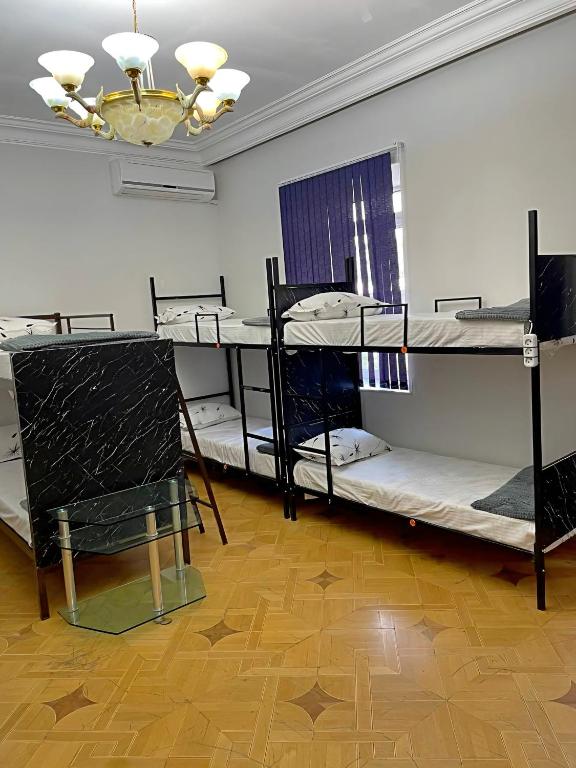 a room with three bunk beds and a chandelier at Olympic Hostel in Yerevan