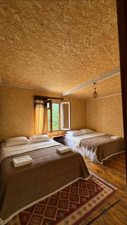 a bedroom with two beds and a window at Ela in Ushguli