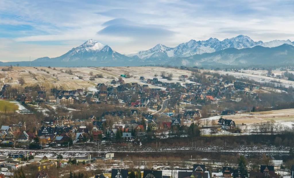 a city with snow capped mountains in the background at U Stocha - Jacuzzi & sauna - dom dla 13 osób in Poronin