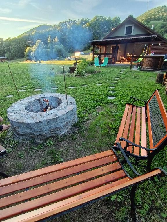 a wooden bench sitting next to a fire pit at Chata Pohodička in Banský Studenec