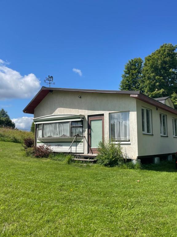 a small house with a green lawn in front of it at Valterkrasti in Ogureckaja
