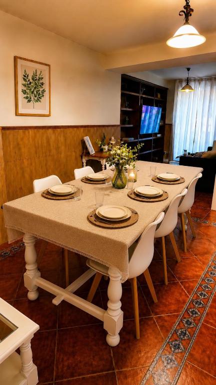 a dining room table with white chairs and a large table at Casa Eloah in Antequera