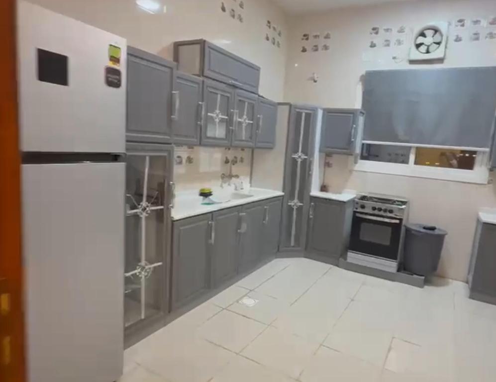 a kitchen with stainless steel appliances and gray cabinets at الوجه مخطط 110 in Al Wajh