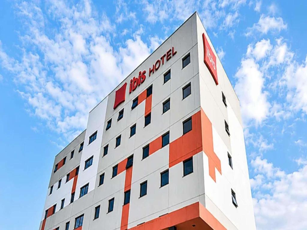 a tall building with a red and white at ibis Araguaína in Araguaína