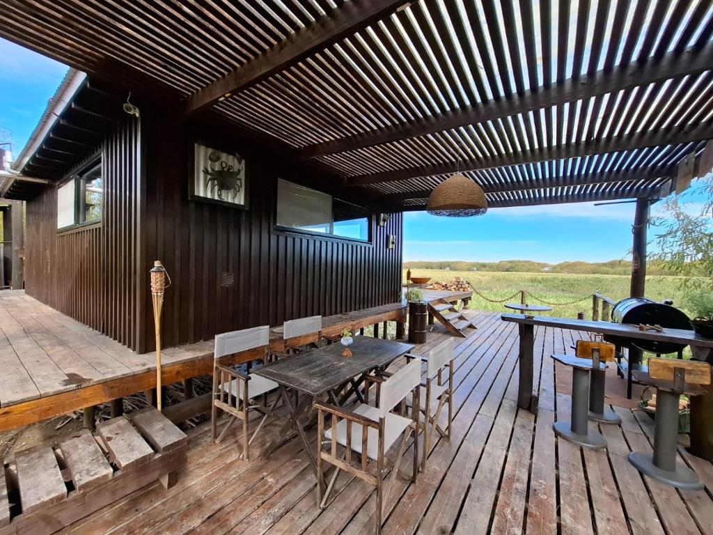 a wooden deck with a table and chairs on it at Irupecita Refugio Isleño in Victoria