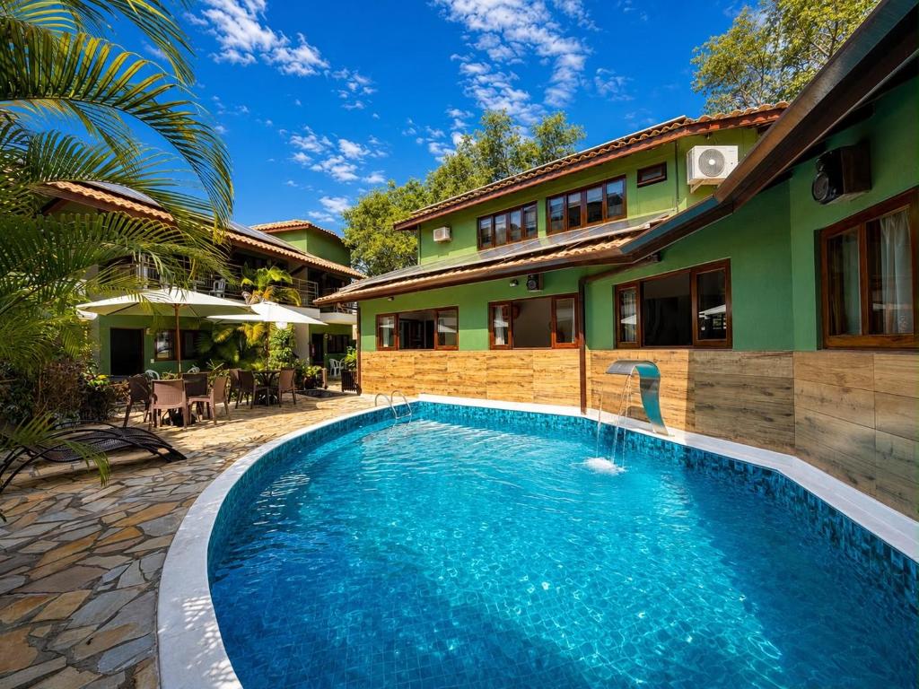a swimming pool in front of a house at Pousada Morada da Praia - Ubatuba -Praia Grande in Ubatuba