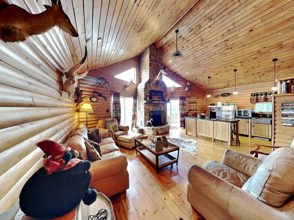 a living room with couches and a log wall at Windy Acres in Oakland