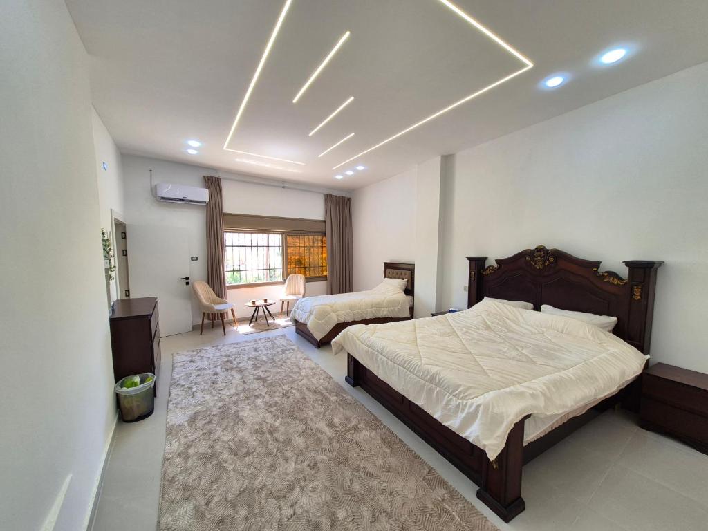 a bedroom with two beds and a television in it at Heart of Jerash in Jerash