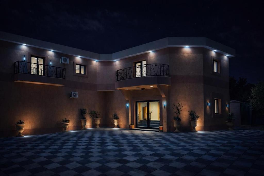 a large building with a checkered floor at night at Hotel Murex in Brazzaville