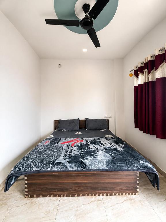a bedroom with a bed with a ceiling fan at Hotel Tiger Paradise in Mahirāvani