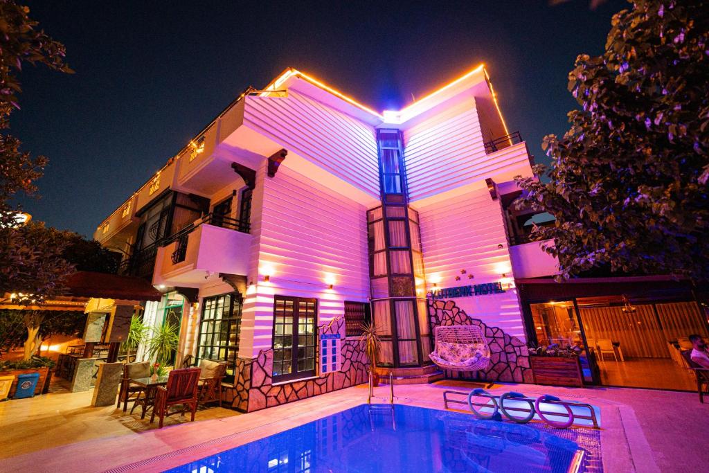 a house with a pool in front of it at night at Kutberk Hotel Kemer in Kemer