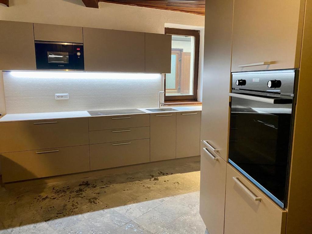 a kitchen with white cabinets and a stove top oven at Chalet Motta in Valtournenche