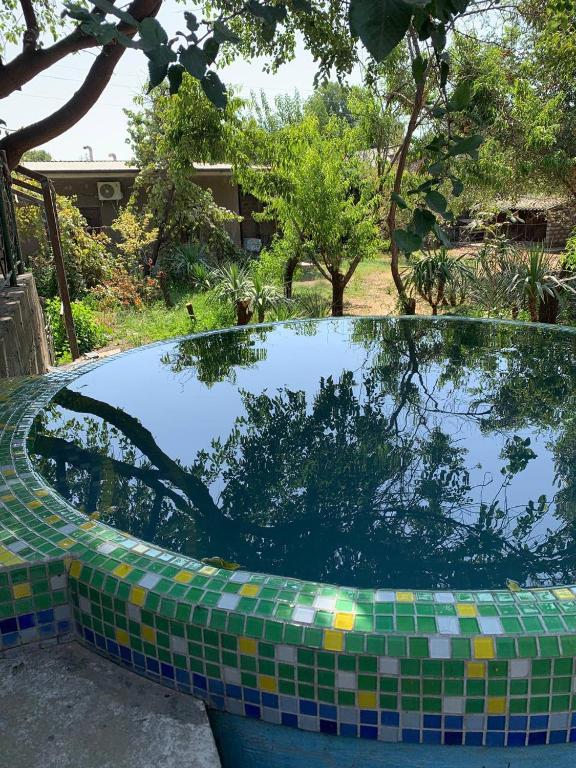 a pool of water with a tiled rim in a yard at Muassanit House - Onix in Stantsiya Kyzyl-Tukumachi