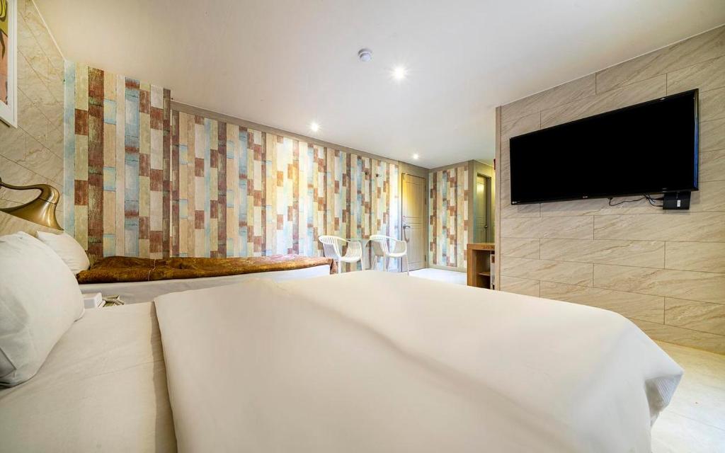 a hotel room with a bed and a flat screen tv at Hotel Fiona in Seoul