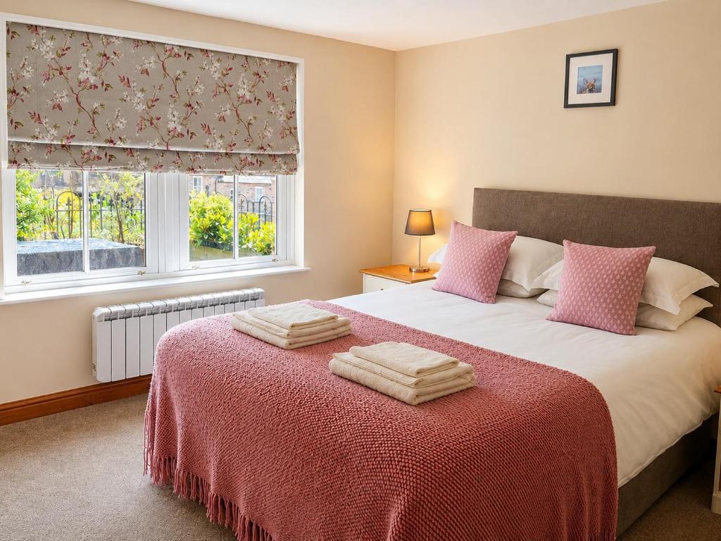 a bedroom with a bed with two towels on it at Howgills Apartments in Sedbergh