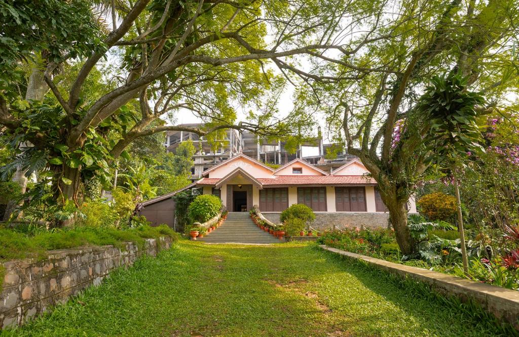 a pink house with a staircase leading to a yard at amã Stays & Trails - Fairholme Bungalow ,Yercaud in Yercaud