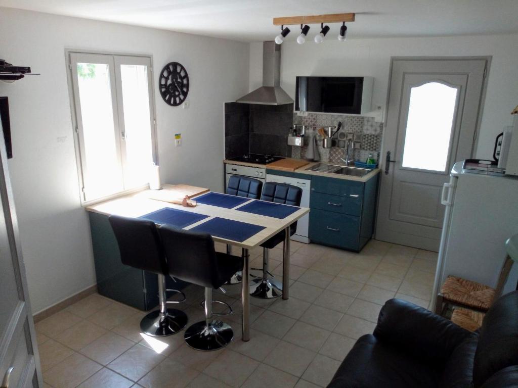 a kitchen with a table and a blue counter top at Le chèvrefeuille in Sahune