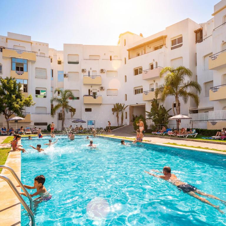 a group of people swimming in a swimming pool at Fantastique Appartement avec piscine sur la plage de Achakar de Tanger - proche du Cap Spartel & la Grotte d'Hercule de TANGER in Tangier