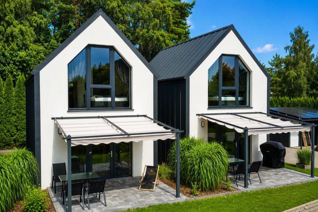 a house with a black roof and windows at Sosnowa Polana Rusinowo in Rusinowo