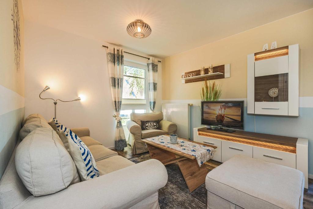 a living room with a couch and a tv at Loddin Ferienwohnung Inselzeit in Loddin