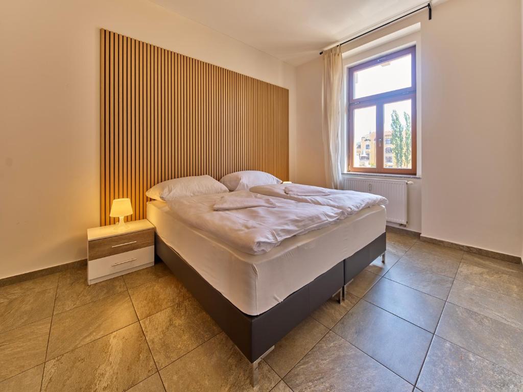 a bedroom with a large bed with a window at Teplice Apartments U Schodů in Teplice