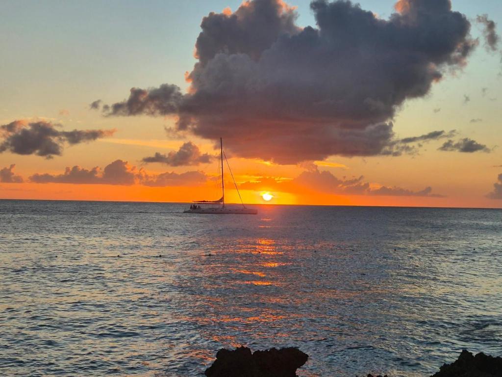 a sail boat in the ocean at sunset at Viva paradise in Punta Cana