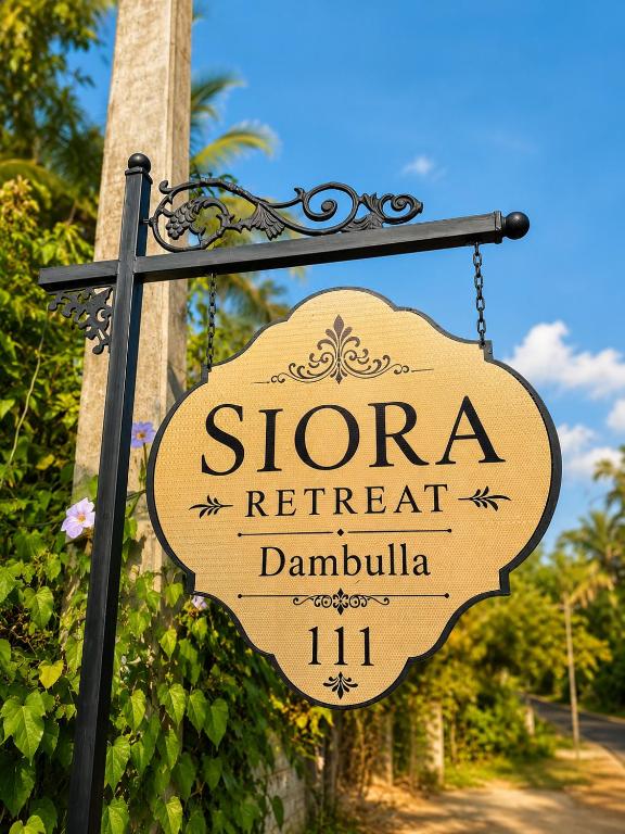 a sign for a retreat in a garden at SIORA Retreat in Dambulla