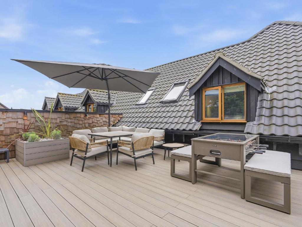 a patio with a table and chairs and an umbrella at The Penthouse - Uk52276 in Beccles