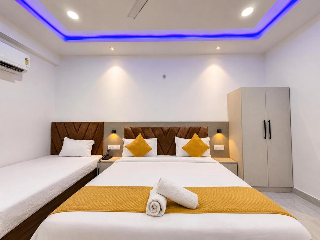 two beds in a room with blue lights on the ceilings at Hotel Shanti Residency Vrindavan in Vrindāvan