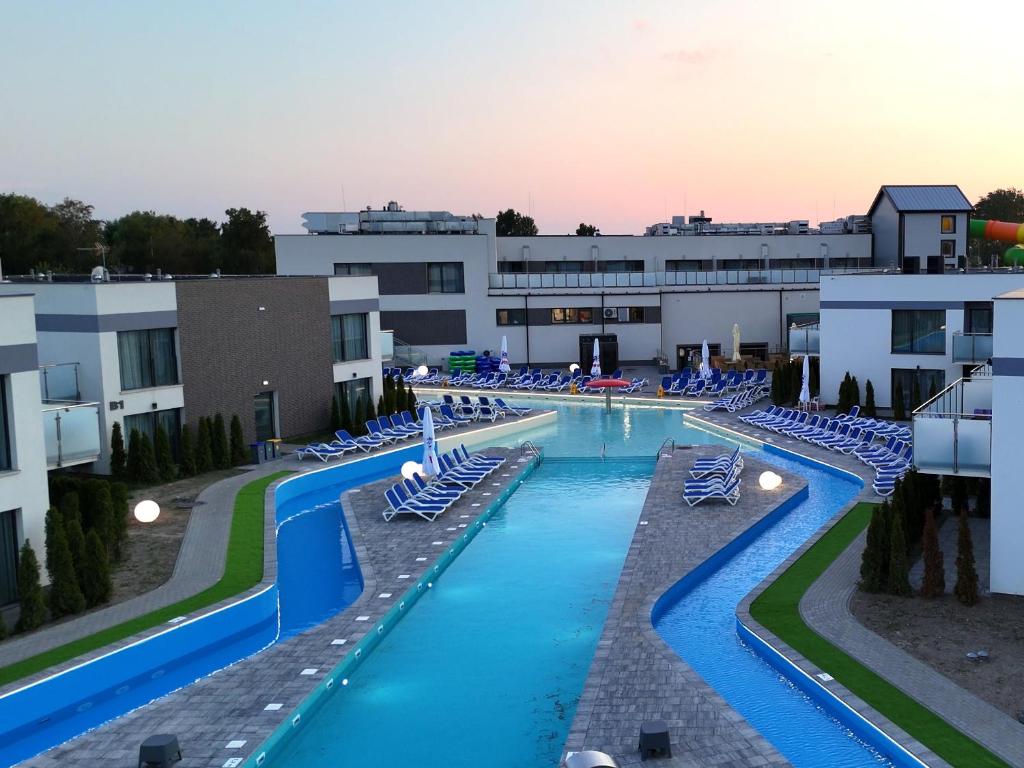 a swimming pool with lounge chairs in a building at Hotel i Apartamenty Gorzelanny Dźwirzyno in Dźwirzyno