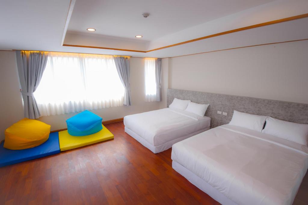 Cette chambre comprend 2 lits et une fenêtre. dans l'établissement Glur Central Pratunam, à Bangkok