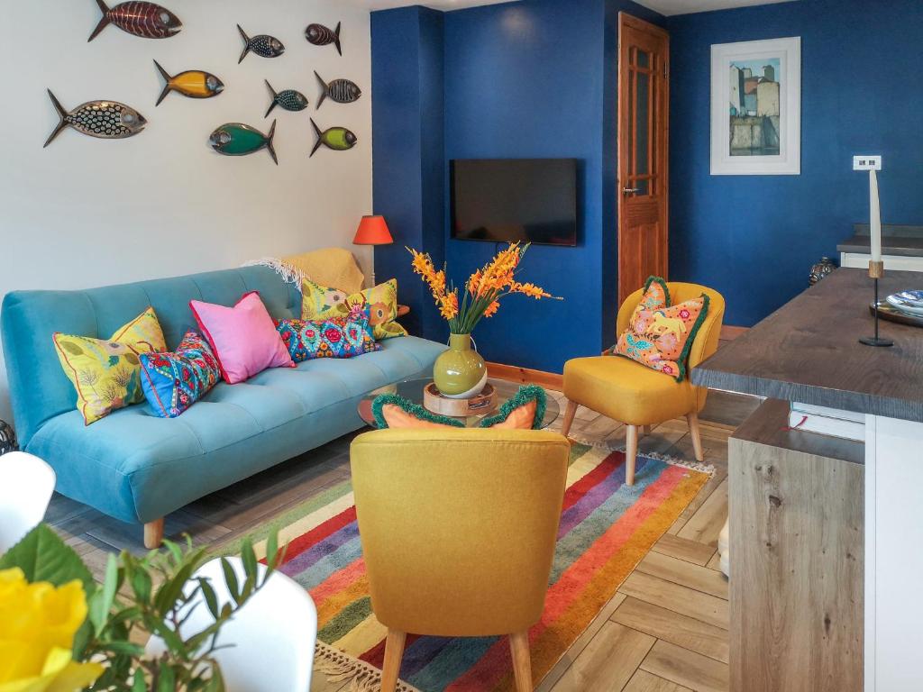 a living room with a blue couch and chairs at Alscott Cottage in Bishops Tawton
