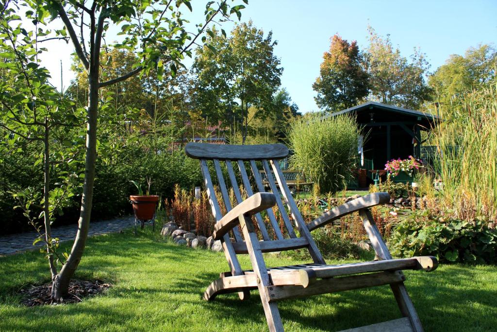 una sedia in legno seduta sull'erba in un giardino di Spreewald Unterkünfte "alte Zigarrenfabrik" Familie Häfner a Lübben