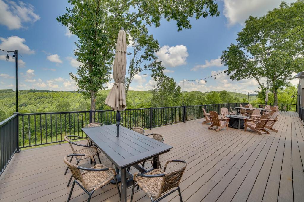 a wooden deck with a table and chairs and an umbrella at Off-Grid & Solar-Powered! Mtn-View Omaha Cabin in Omaha