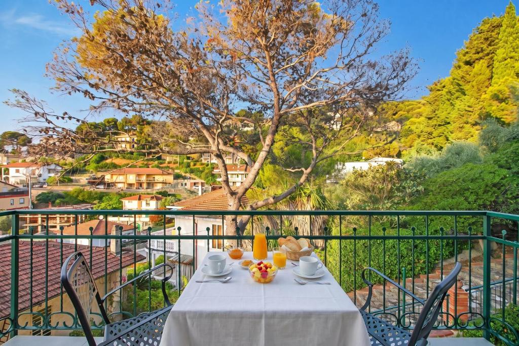 a table with a white table cloth on a balcony at Seaview Pool Retreat - Il Poggio in Marina di Andora