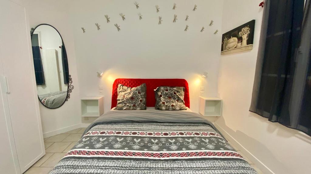 a bedroom with a bed with a red headboard at Gite Escale en Ville in Louviers