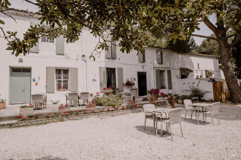 a group of chairs and tables in front of a building at Manade Cavallini - Mas de Pioch in Saintes-Maries-de-la-Mer
