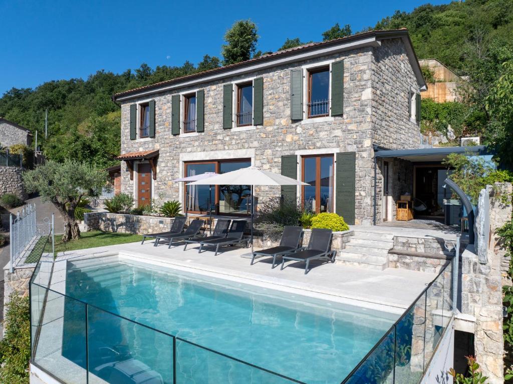 a house with a swimming pool in front of a house at Vila Marigold in Opatija