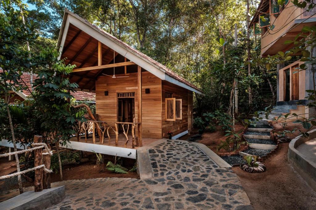 a cabin in the woods with a pathway leading to it at Manthally Cabanas in Hikkaduwa