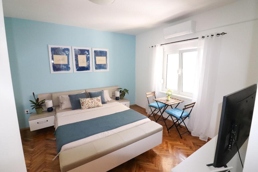 a bedroom with a bed and a tv and a table at Bonaca Room in Donja Lastva