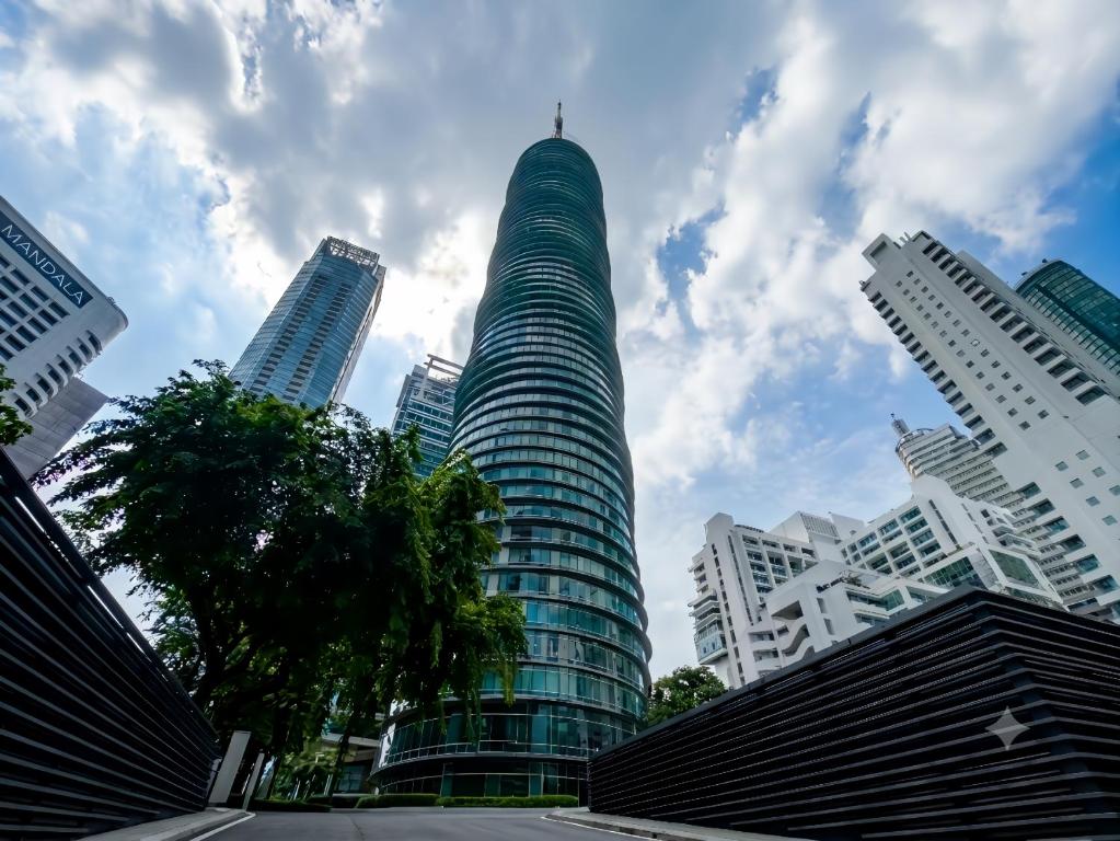 a tall glass building in a city with buildings at Vortex Premium Apartment klcc in Kuala Lumpur